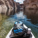 sac à dos bleu et noir sur un bateau blanc sur un lac pendant la journée