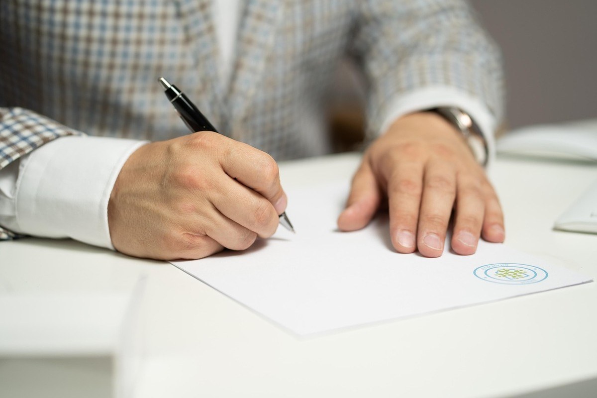 Deux personnes se serrent la main au-dessus de documents sur une table de réunion Deux personnes se serrent la main au-dessus de documents sur une table de réunion