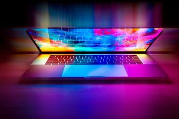 Un ordinateur portable ouvert sur une table, écran coloré