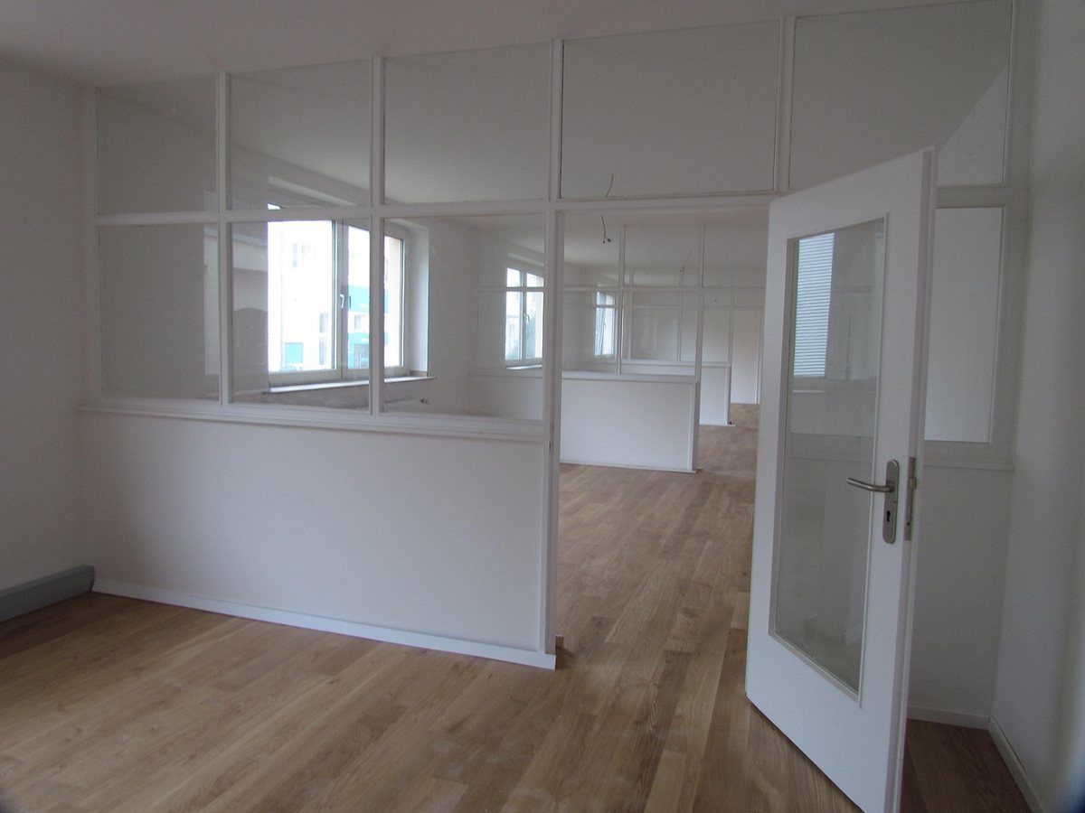 Intérieur d'une pièce vide porte ouverte cloisons vitrées parquet clair