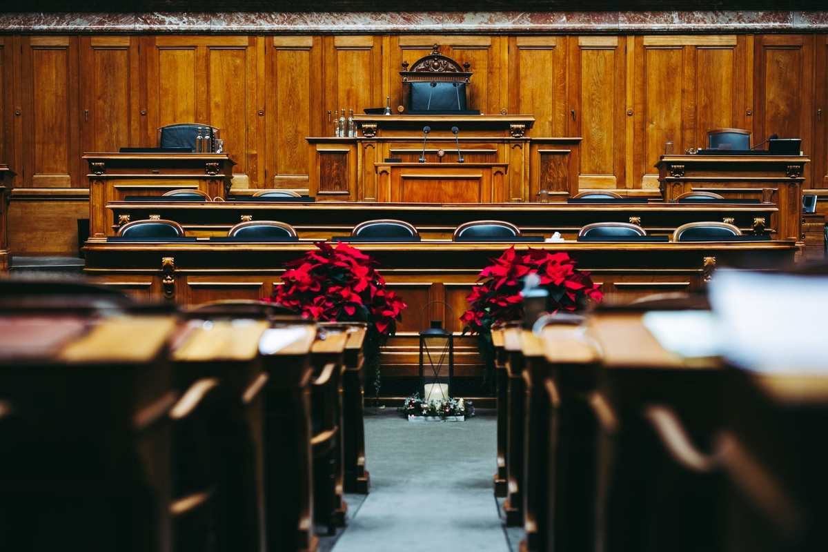 Salle de réunion en bois avec des bureaux, des chaises et des arrangements floraux rouges